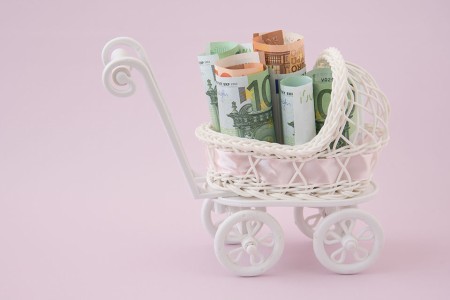 Miniaturkinderwagen mit Geldscheinen